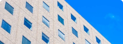 Illustration : façade claire aux fenêtres régulières, vue en contre-plongée.