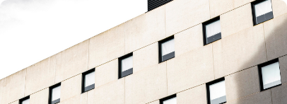 Illustration : façade claire aux petites fenêtres régulièrement espacées.