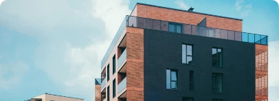 Illustration : immeuble à façades de briques et de panneaux sombres, avec terrasse en toiture.