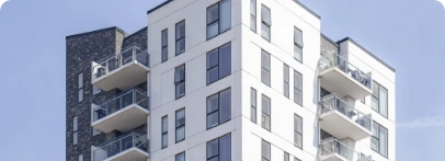 Illustration : immeuble aux façades claires et sombres avec balcons superposés.